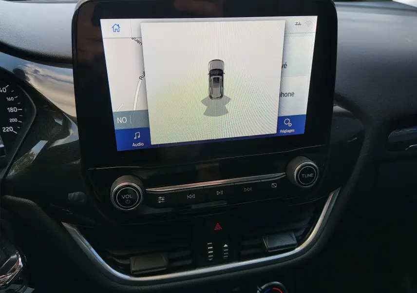 Écran tactile central du Ford Puma 2021 blanc montrant la caméra de recul avec commandes audio intégrées.