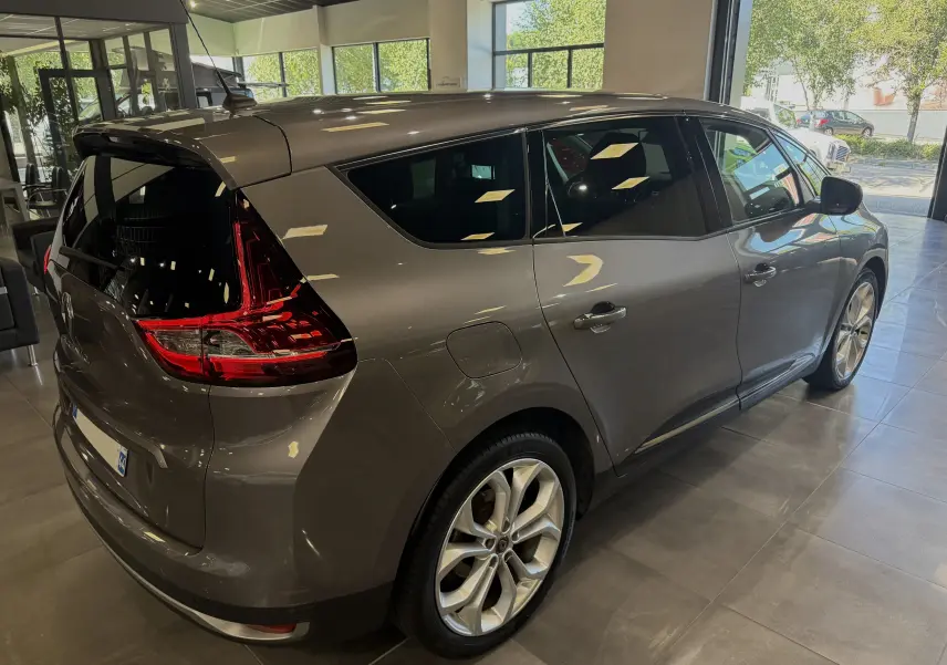 Renault Grand Scenic IV Business gris cassiopée vu en 3/4 arrière droit, avec feux arrière LED et jantes alliage.