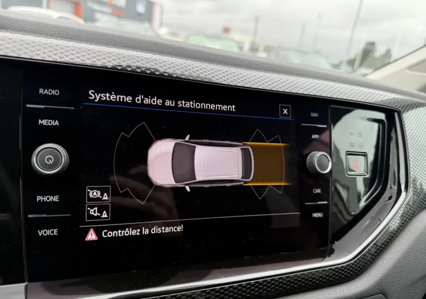 Vue rapprochée de l'écran tactile intérieur du Volkswagen Taigo 2024 affichant le système d'aide au stationnement.