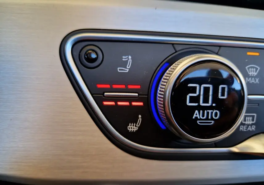 Gros plan sur le bouton de réglage de la climatisation à 20°C avec siège chauffant activé dans l'Audi A5 Cabriolet noir.