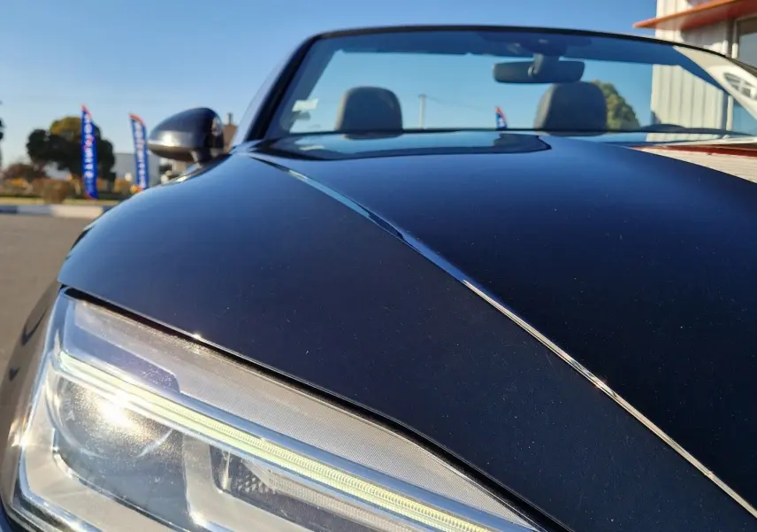 Gros plan sur le phare avant gauche d'une Audi A5 Cabriolet noire 2017, soulignant son design LED moderne.