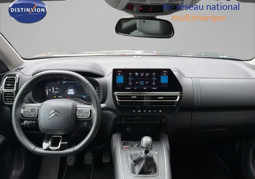 Vue intérieure frontale du tableau de bord et volant du Citroën C5 Aircross gris platinium, avec boîte manuelle et écran tactile central.