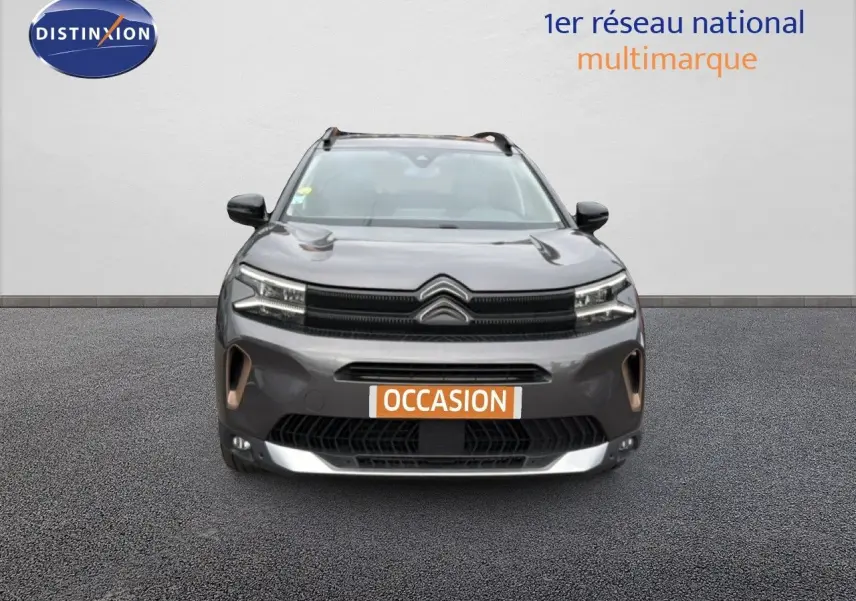Vue de face du Citroën C5 Aircross gris platinium 2022 avec calandre distinctive et phares LED allumés.