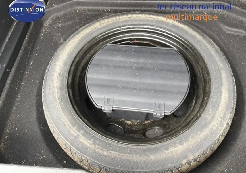 Vue plongeante sur la roue de secours et le compartiment de rangement dans le coffre du Citroën C5 Aircross gris platinium.