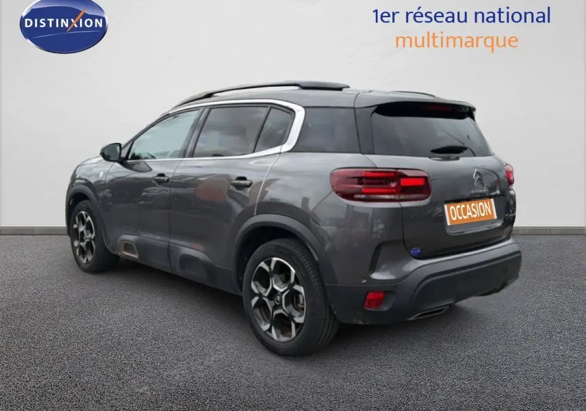 Vue 3/4 arrière droite d'un Citroën C5 Aircross gris platinium avec jantes bi-ton et toit noir.