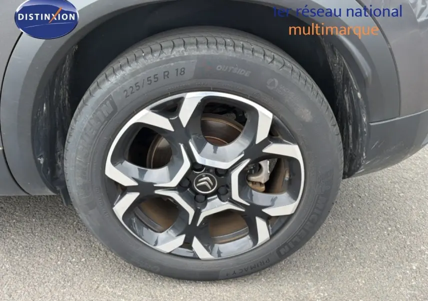 Gros plan sur la roue arrière droite du Citroën C5 Aircross gris platinium avec jante alliage bicolore distinctive.