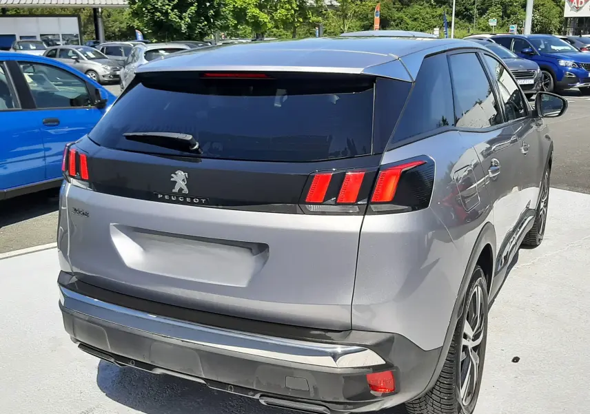 Vue 3/4 arrière droite d'un Peugeot 3008 gris Artense avec feux arrière à griffes et vitres teintées.