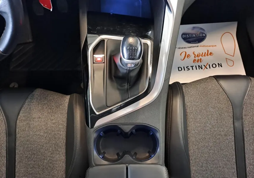 Vue plongeante sur la console centrale du Peugeot 3008 gris, mettant en valeur le levier de vitesse manuel et les sièges tissu-cuir.