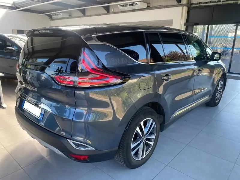 Vue 3/4 arrière droite d'un Renault Espace V gris métallisé avec vitres surteintées et feux arrière LED distinctifs.