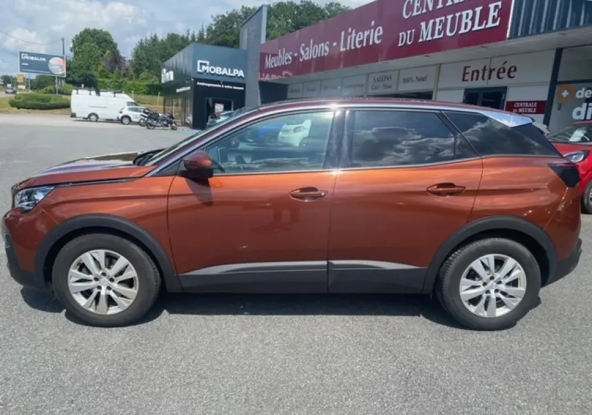 Profil côté gauche d'un Peugeot 3008 2019 métallisé copper avec jantes alliage 17 pouces sur parking extérieur.