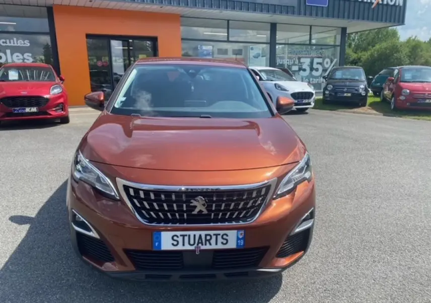 Vue frontale d'un Peugeot 3008 2019 métallisé copper avec calandre chromée et phares LED diurnes.