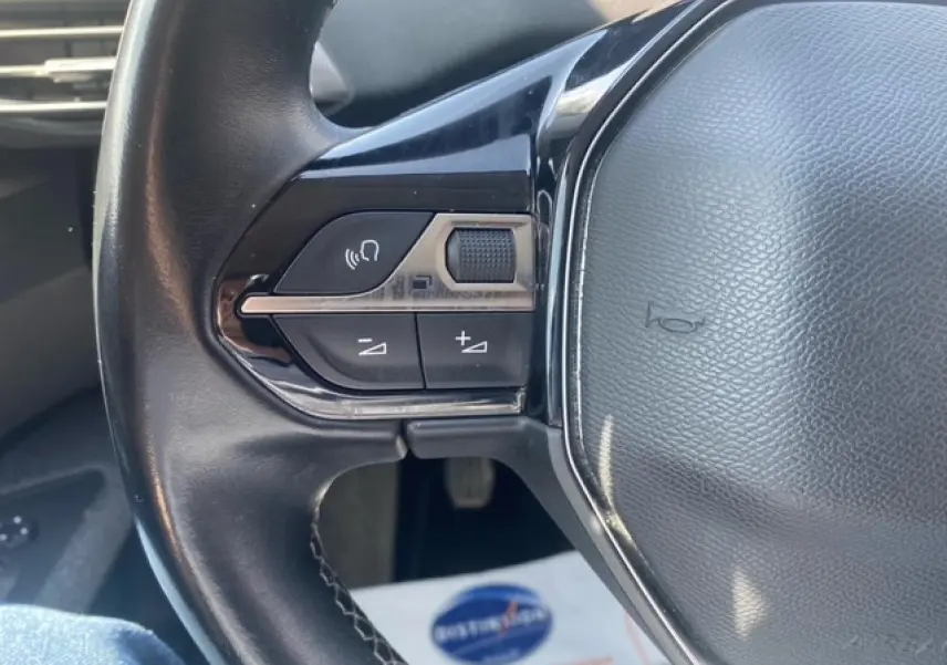 Gros plan sur les commandes audio au volant en cuir noir du Peugeot 3008 2019 finition Active Business.