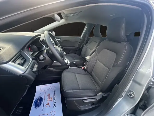 Intérieur avant du Renault Captur TCE 90 Evolution 2024 en gris Highland, sièges tissu noir et tableau de bord moderne.