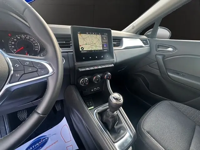 Intérieur du Renault Captur TCE 90 Evolution 2024, vue côté passager montrant tableau de bord, écran tactile et levier de vitesse manuel.