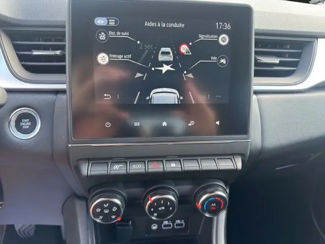 Écran tactile central du tableau de bord du Renault Captur gris Highland 2024 montrant les aides à la conduite.