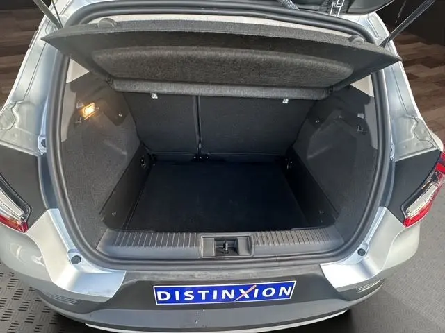 Coffre ouvert vu de l'arrière d'un Renault Captur TCE 90 Evolution gris Highland, montrant un espace de chargement propre et spacieux.