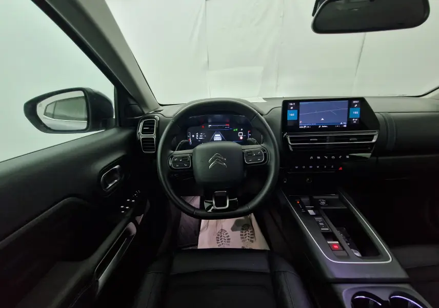 Intérieur noir du Citroën C5 Aircross 2024 vu du poste de conduite, avec tableau de bord numérique et écran tactile central.