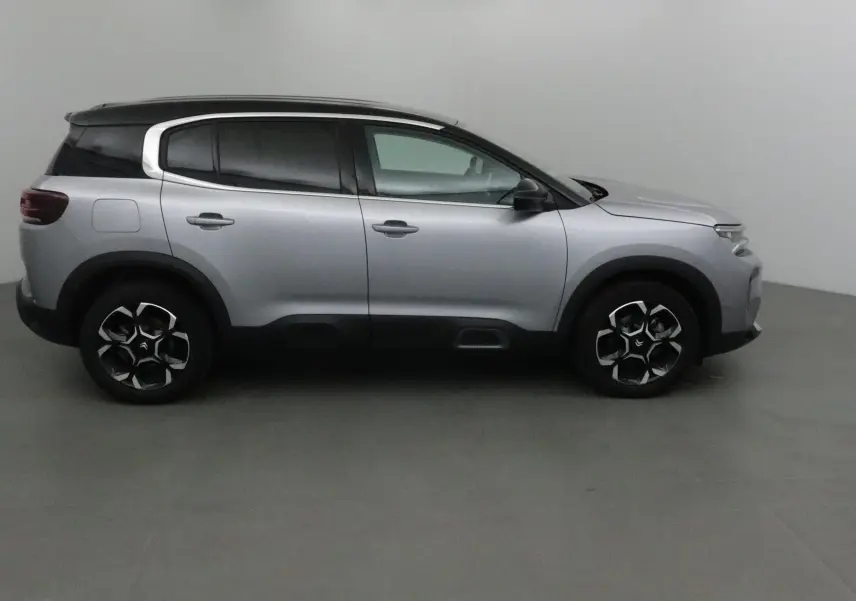 Vue latérale droite d'un Citroën C5 Aircross 2024 gris Artense avec toit noir et jantes originales.