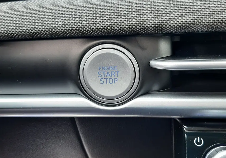 Gros plan sur le bouton start/stop du moteur dans l'habitacle du Hyundai Tucson 2025, finition noire et grise.