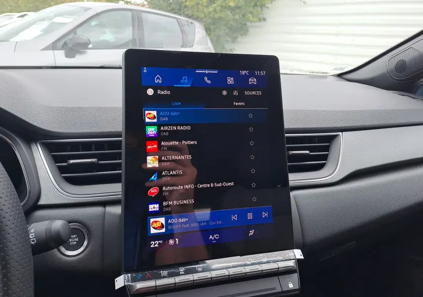 Vue intérieure du tableau de bord de la Renault Symbioz 2025 avec écran tactile central affichant la radio numérique.