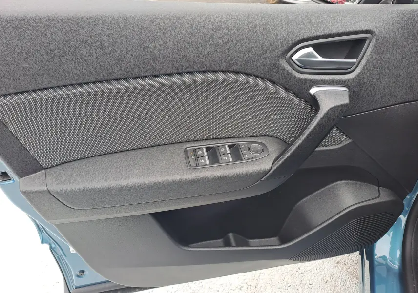 Porte côté gauche ouverte de la Renault SYMBIOZ 2025 bleu mercure, montrant les commandes électriques et poignée intérieure.