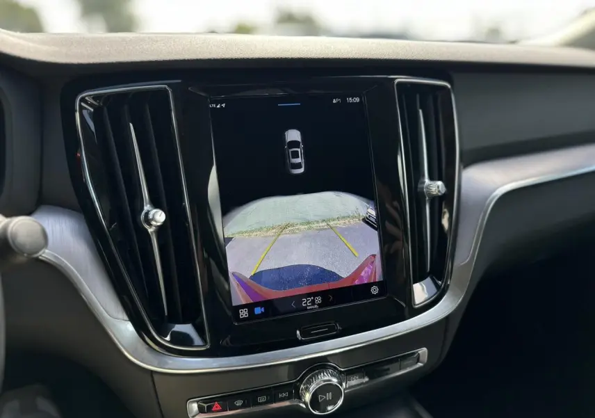 Écran tactile central affichant la caméra de recul du Volvo S60 rouge Fusion, intérieur moderne avec aérateurs noirs.