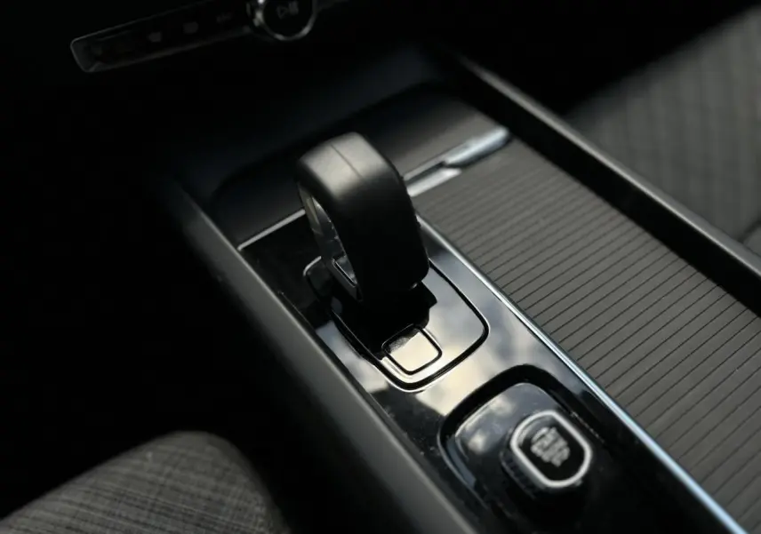 Gros plan sur le levier de vitesses automatique et le bouton de démarrage du Volvo S60 2024, intérieur noir élégant.