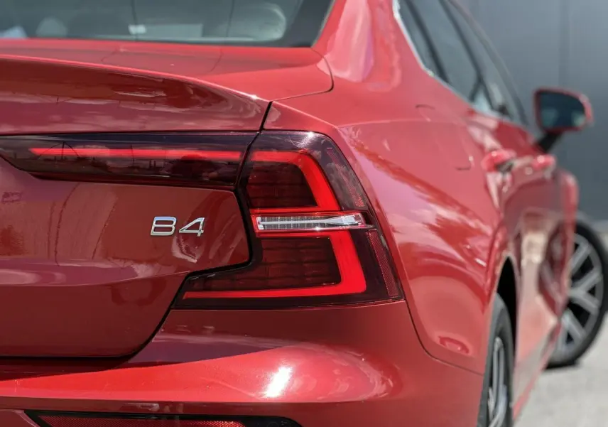 Gros plan sur l'arrière droit rouge Fusion d'une Volvo S60 B4 2024, mettant en valeur le feu LED et l'inscription B4.