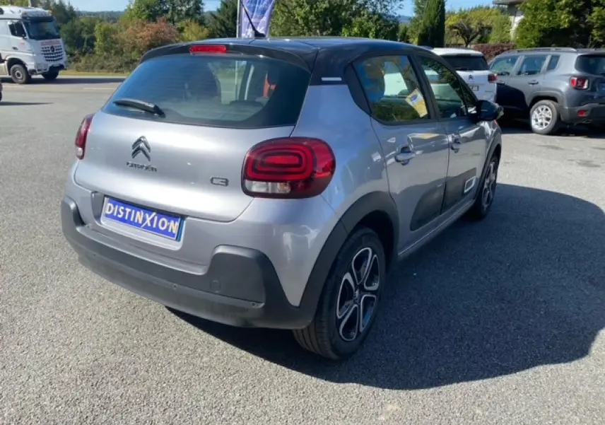 Citroën C3 gris Artense métal vue 3/4 arrière droit avec toit noir et enjoliveurs 3D distinctifs.