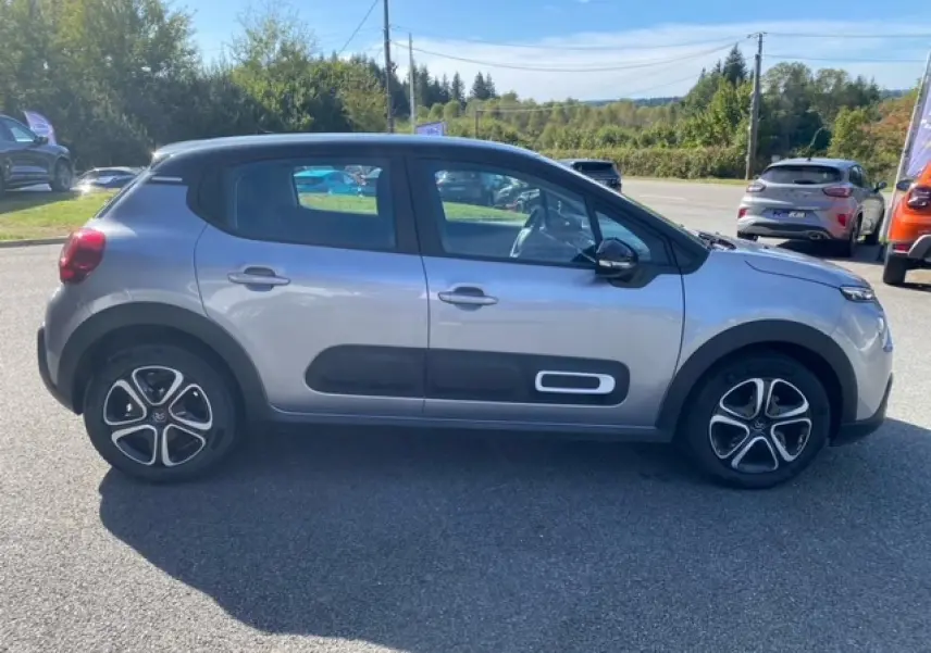 Profil côté gauche d'une Citroën C3 gris Artense métal avec Airbump noir et jantes 16 pouces en extérieur ensoleillé.