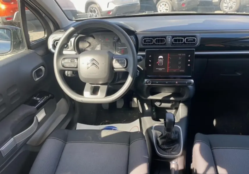 Vue intérieure avant de la Citroën C3 1.2 Shine 2022, montrant le volant, tableau de bord et écran tactile central.