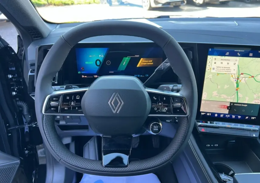 Vue intérieure centrée sur le volant du Renault Austral E-Tech 200 2025 avec tableau de bord numérique et écran tactile.