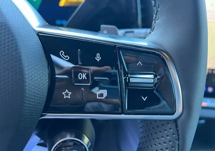 Gros plan sur les commandes tactiles du volant du Renault Austral E-Tech 200 Techno 2025 en cuir noir perforé.