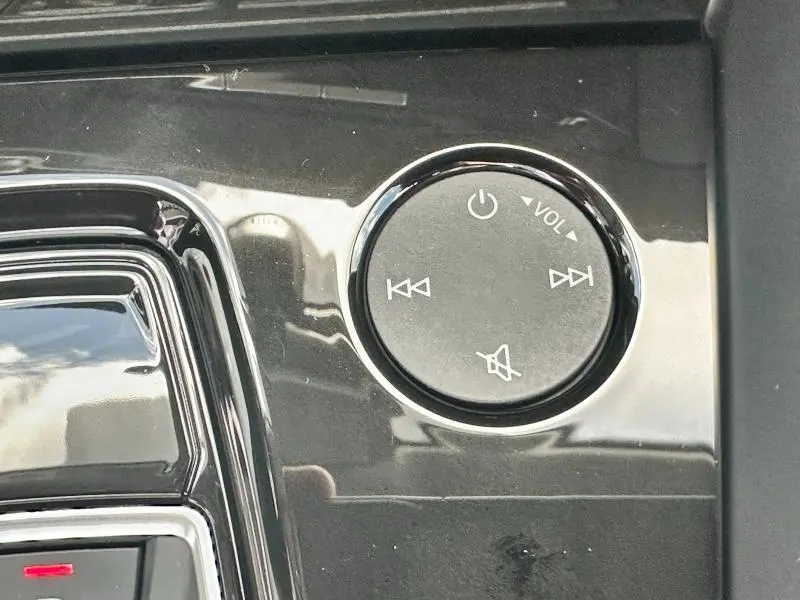 Bouton circulaire de contrôle audio noir brillant sur console centrale d'une Audi A3 Sportback 30 TFSI 2024.