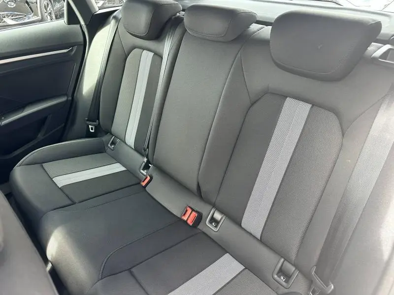 Vue intérieure de la banquette arrière en tissu noir et gris de l'Audi A3 Sportback 2024 hybride.