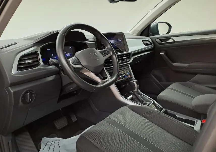 Intérieur avant droit du Volkswagen T-Roc 1.5 TSI 150 DSG7 Life avec tableau de bord moderne et volant multifonction noir.