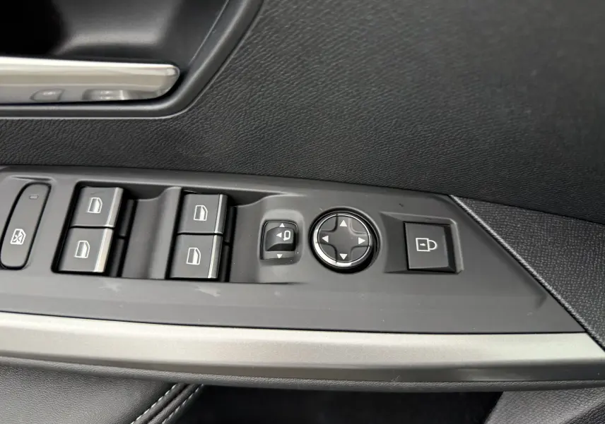 Commandes des vitres et réglages des rétroviseurs sur la porte côté conducteur d'un Peugeot 3008 Hybrid blanc 2025.