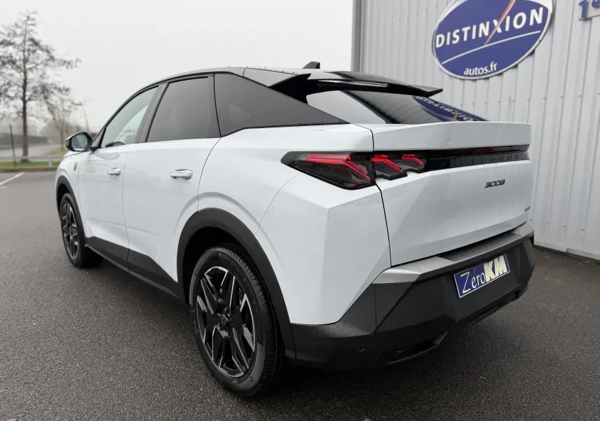 Peugeot 3008 Hybrid blanc Okenite avec toit noir, vue 3/4 arrière droit, feux arrière LED distinctifs et jantes noires.