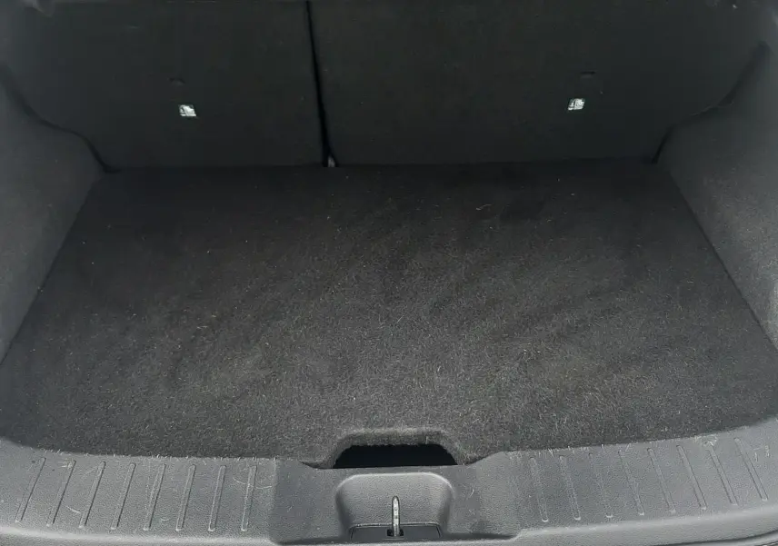 Coffre ouvert d'un Nissan Juke gris 2020, vue de l'arrière montrant un espace de chargement propre et vide.