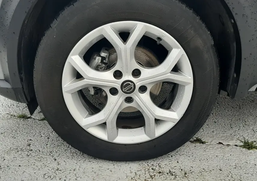 Gros plan sur la roue avant droite grise d'un Nissan Juke 2020 avec jante alliage et logo Nissan au centre.