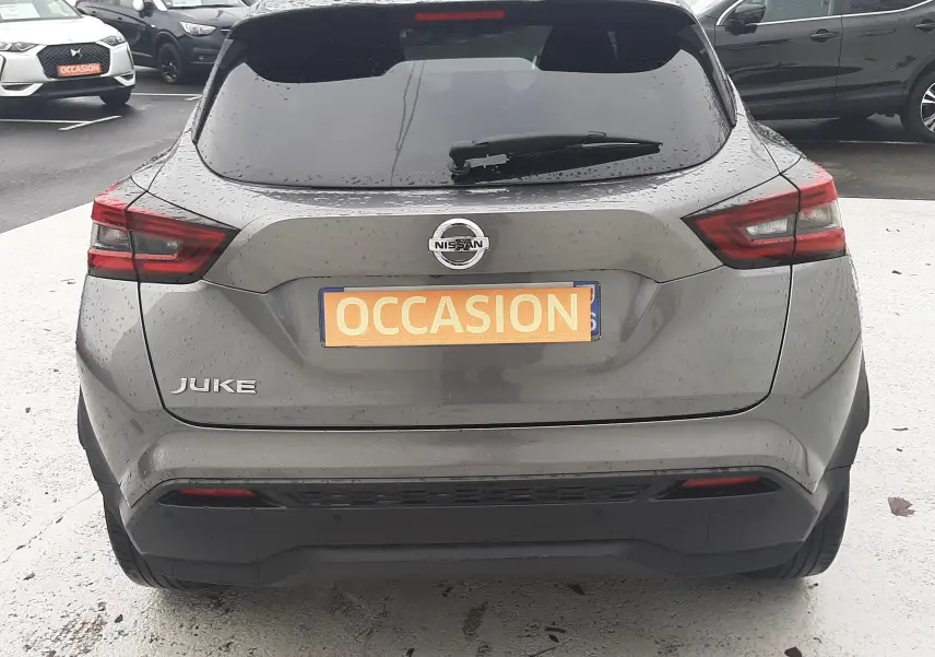 Vue arrière d'un Nissan Juke gris 2020 avec feux arrière LED et plaque "OCCASION" sur un parking.