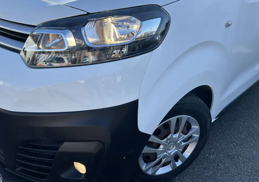 Gros plan sur l'avant droit blanc du Citroën Jumpy 2017 avec phare allumé et pare-chocs noir mat.