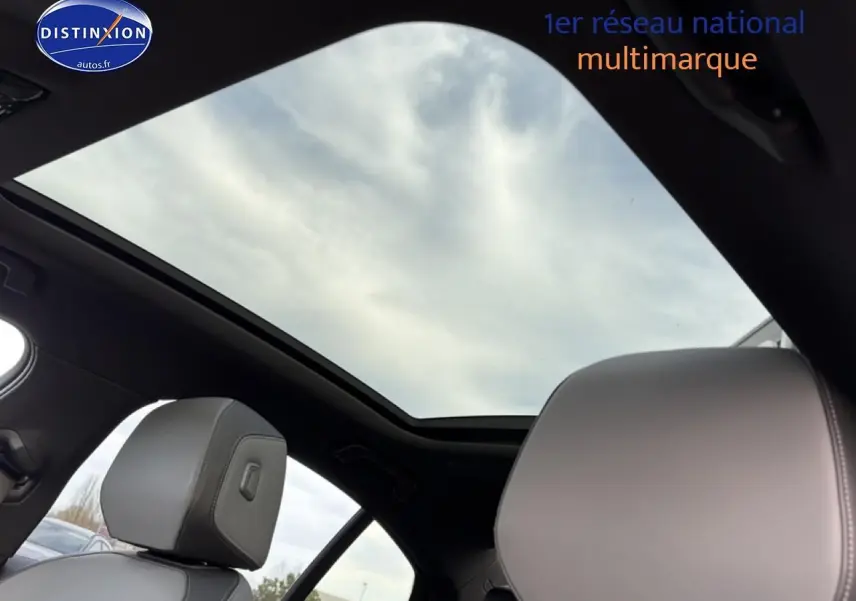 Toit panoramique ouvert avec ciel nuageux visible, intérieur noir et sièges gris clair de la BMW Série 5 i5 M60 2024.