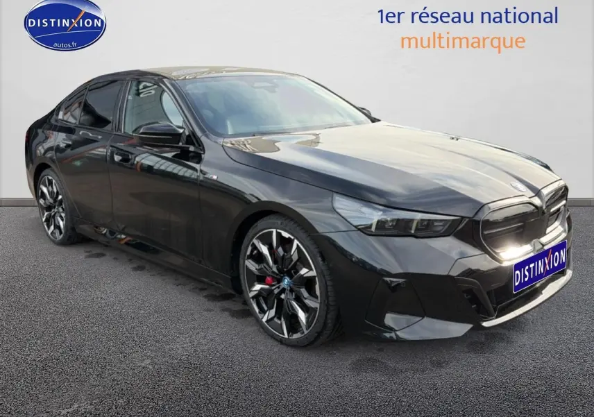 BMW Série 5 i5 M60 noir vue 3/4 avant droit, avec jantes alu bicolores et calandre marquée M Sport.