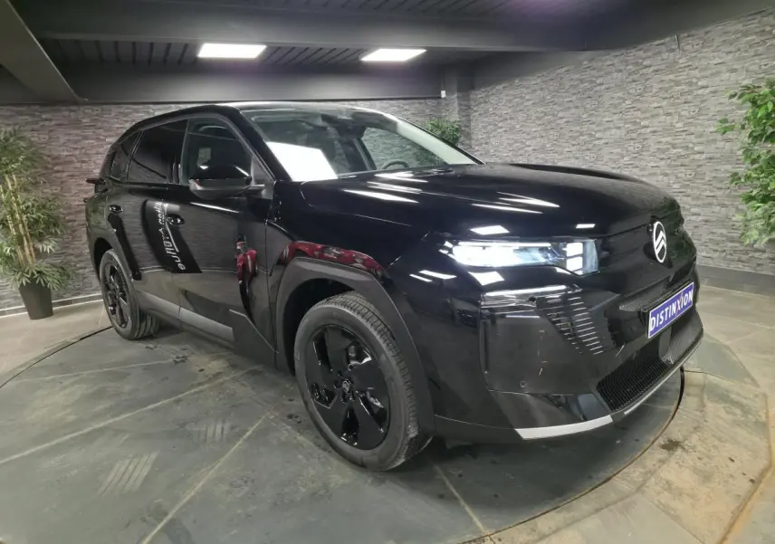 Citroën C5 Aircross noir en 3/4 avant droit, avec jantes noires et calandre brillante dans un showroom.