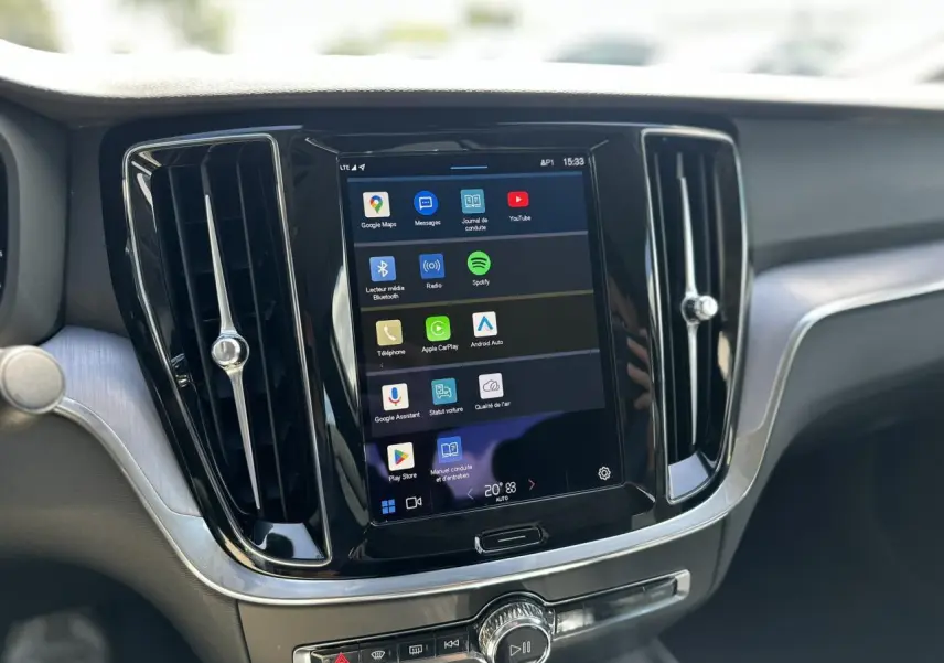 Écran tactile central du tableau de bord du Volvo S60 gris Platinium, avec commandes multimédia et aérateurs noirs.