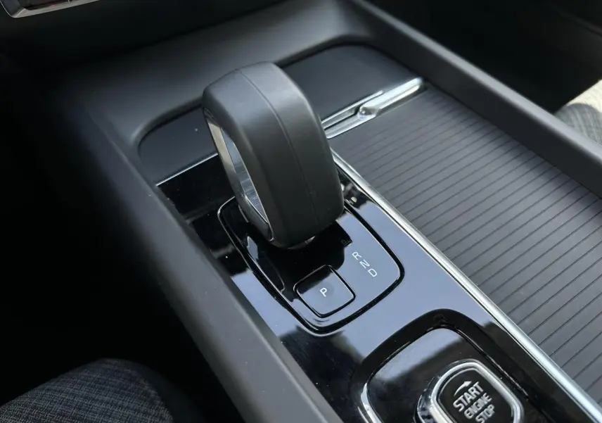 Gros plan sur le levier de vitesses automatique et bouton start/stop de la console centrale d'une Volvo S60 gris Platinium.