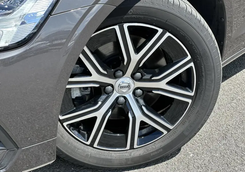 Gros plan sur la jante alliage 17 pouces noire et diamant du côté avant gauche d'une Volvo S60 gris Platinium.