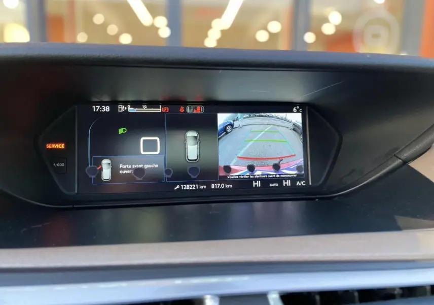 Écran central de la Citroën C4 Picasso rouge foncé affichant la caméra de recul et l'ouverture de la porte avant gauche.