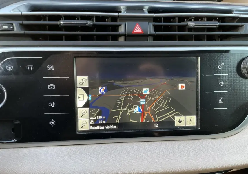 Tablette tactile de navigation affichant une carte dans l'habitacle d'une Citroën C4 Picasso rouge foncé, vue intérieure.